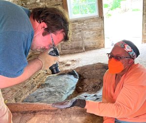 two  people have discovered an artifact in the slave dwelling dig at Historic Sotterley
